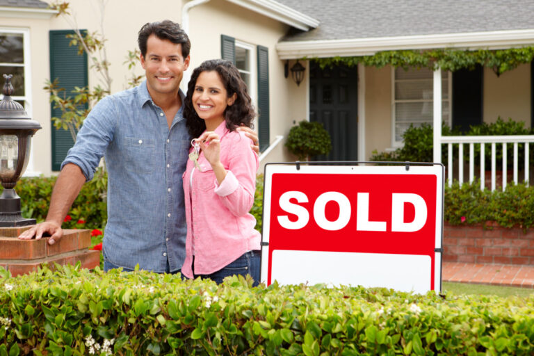 A couple standing outside a sold house