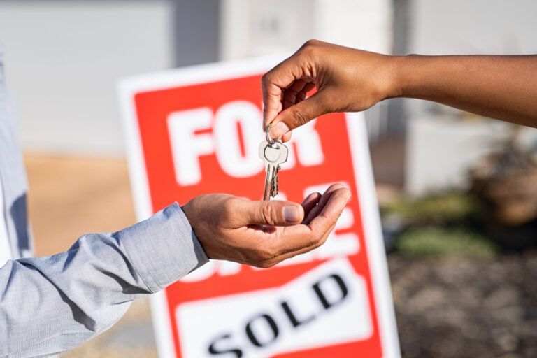 an agent handing house keys to the homebuyer