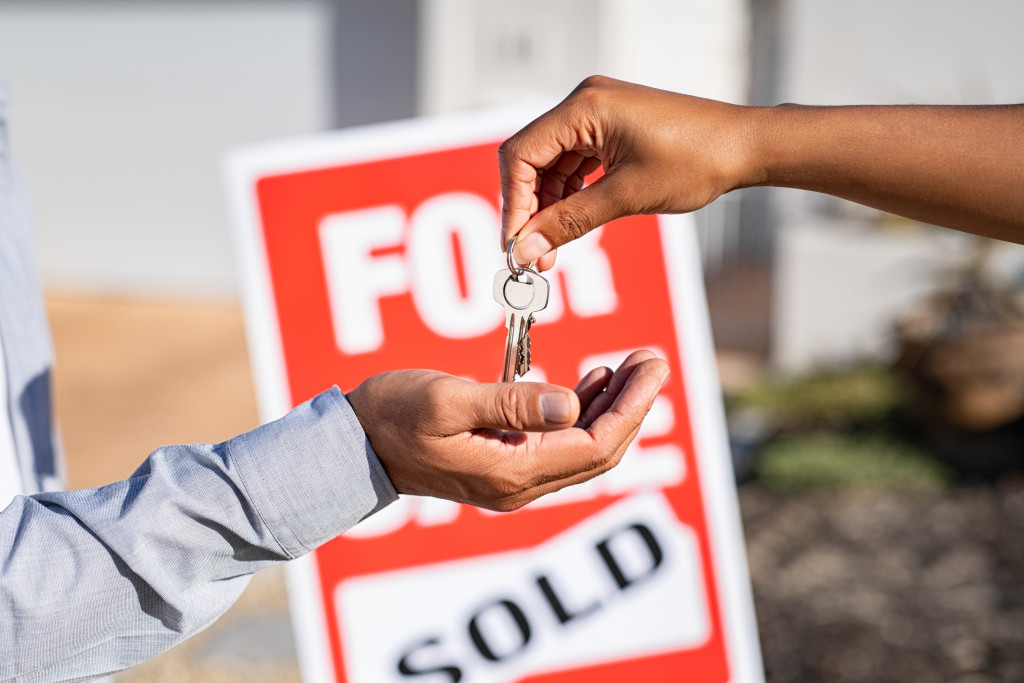 saleswoman giving keys to new property owner