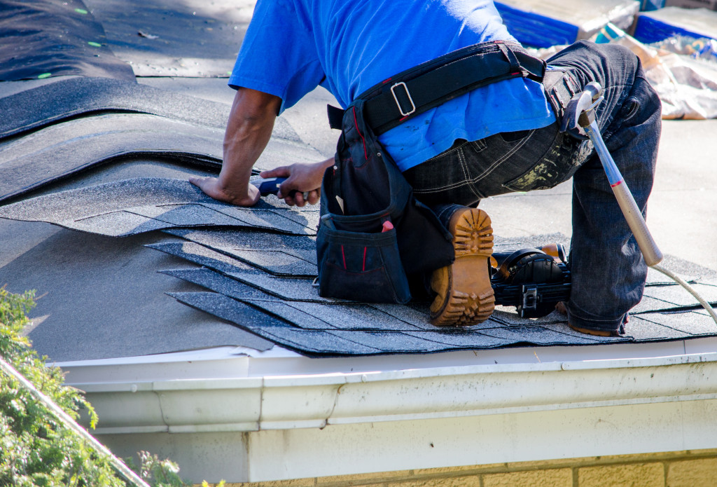 A man repairing the roof of a house